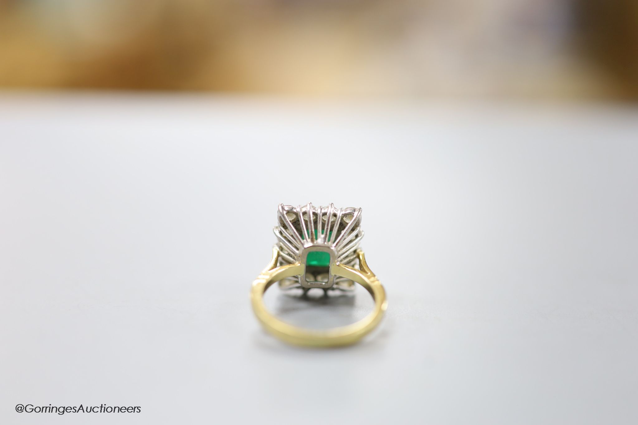 A modern 18ct gold, emerald and diamond set rectangular cluster ring, size K